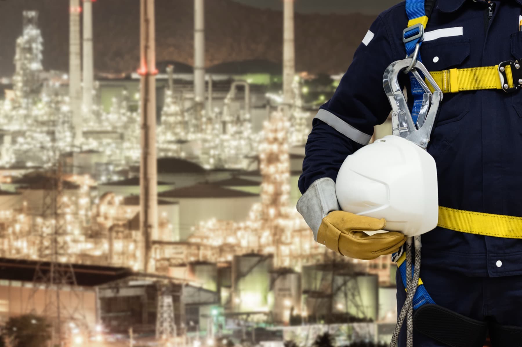 Industrial process plant at night, EHS professional in the foreground